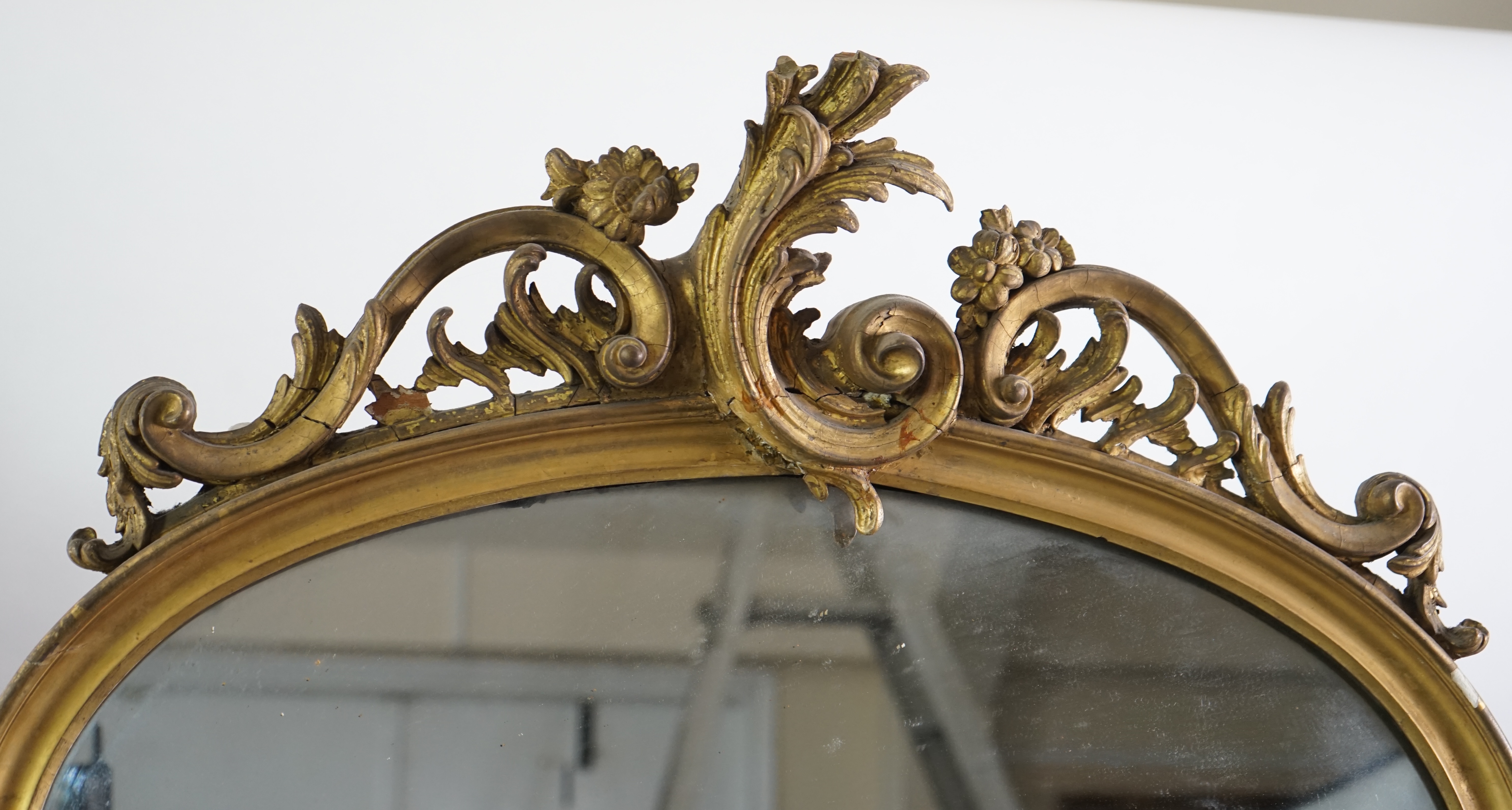 A pair of late 19th century giltwood and gesso pier glasses, with asymmetrical rococo scroll crests and arched plates, 80cm wide, 221cm high. Condition - fair